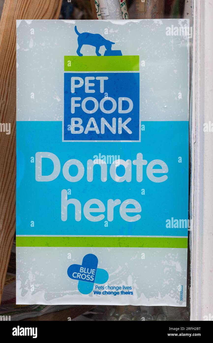 Avviso poster per una PET Food Bank in una vetrina di un negozio di beneficenza Blue Cross Animal Welfare per chiedere donazioni, Inghilterra, Regno Unito Foto Stock
