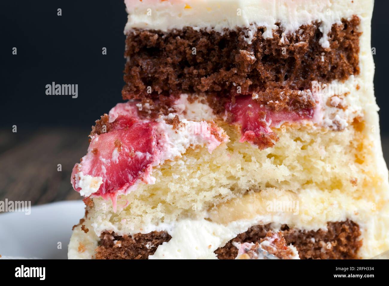 deliziosa torta di dolci misti e farciture di fragole e banane, un pezzo di torta di vaniglia e torte al cioccolato farcite con fragole a. Foto Stock