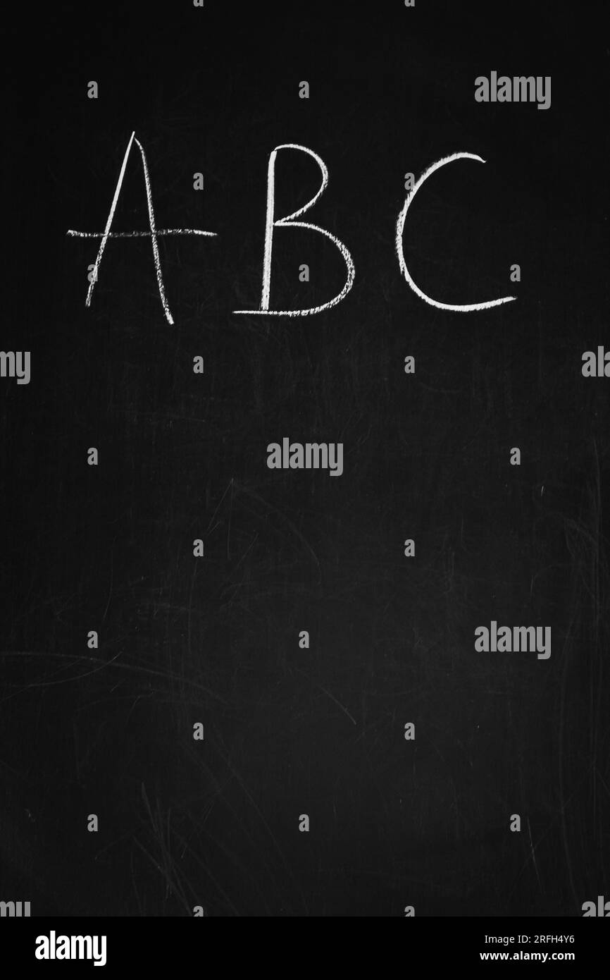 Gesso che disegna su una lavagna. Lettere ABC su tavola di legno. Lavagna scolastica. Concetto alfabetico. Testo scritto a mano. Istruzione prescolare. Foto Stock