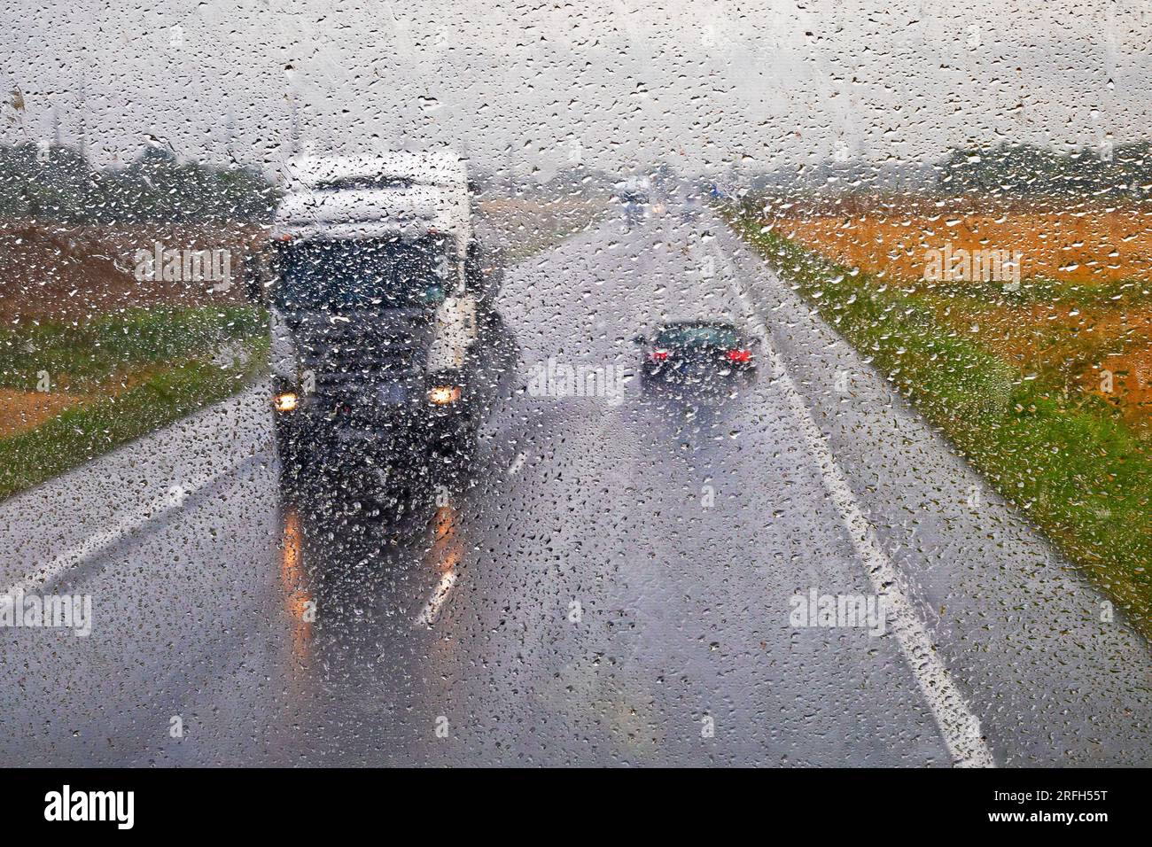 il carrello sta guidando sulla strada principale sdrucciolevole sotto la pioggia. Maltempo Foto Stock
