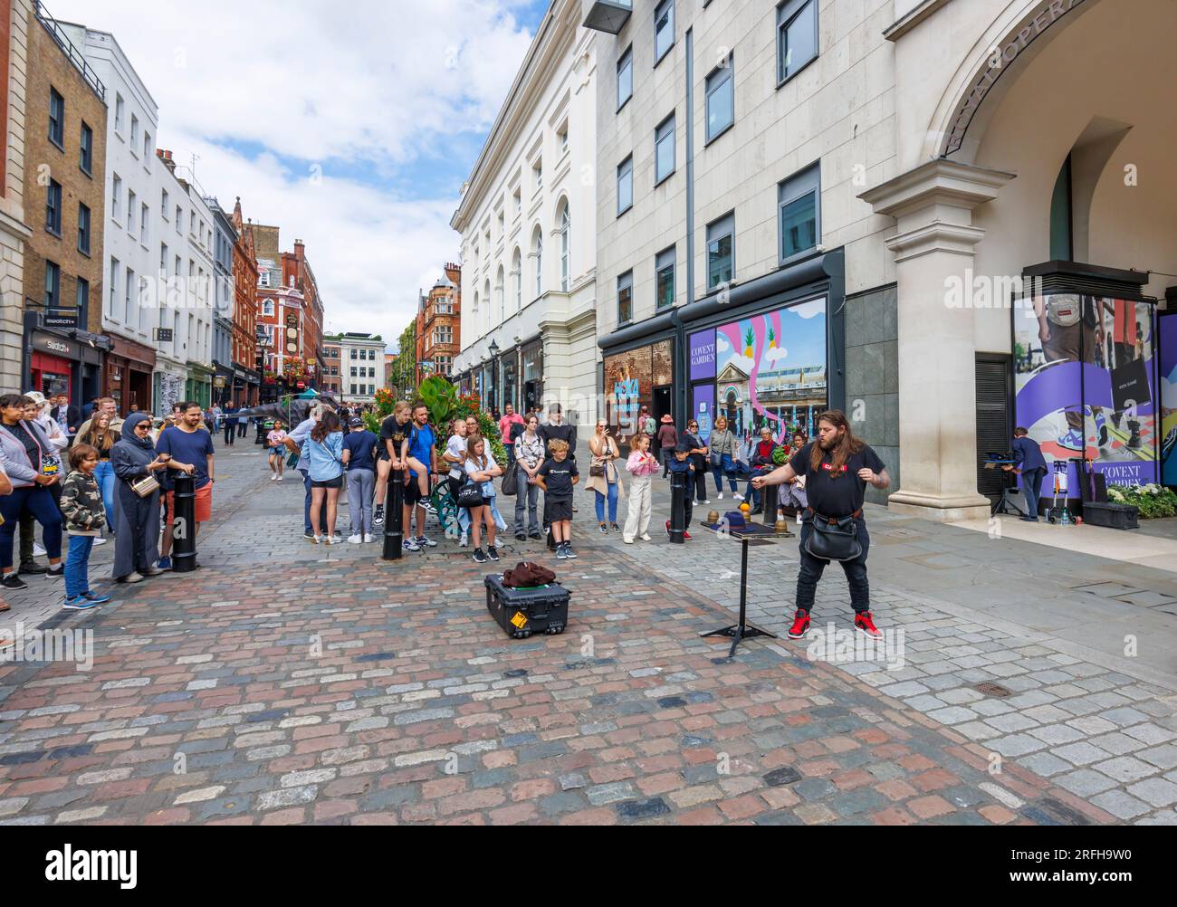 Il mago di strada australiano Jason Maher si esibisce e intrattiene una folla al Covent Garden nel West End di Londra, WC2 Foto Stock