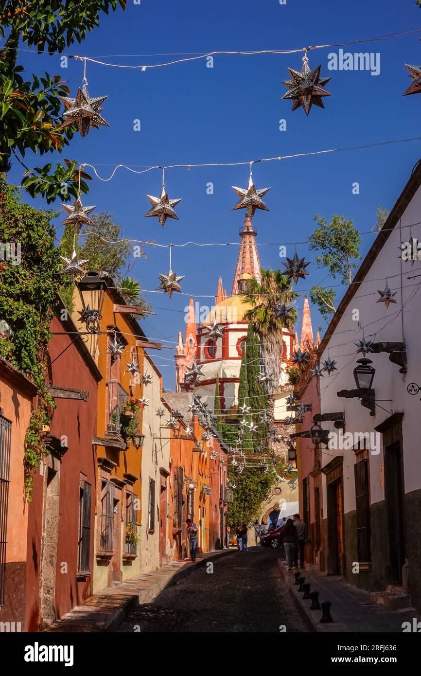 Stelle messicane di latta si stagliavano lungo la Calle Aldama acciottolata con il campanile rosa della Parroquia de San Miguel Arcangel che svetta sopra nel centro storico della città di San Miguel de Allende, Messico. Foto Stock