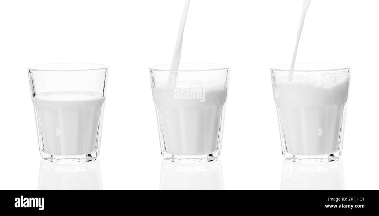 Il latte viene versato nel bicchiere. Spruzzo di latte nel bicchiere e versamento isolato su sfondo bianco. Foto Stock