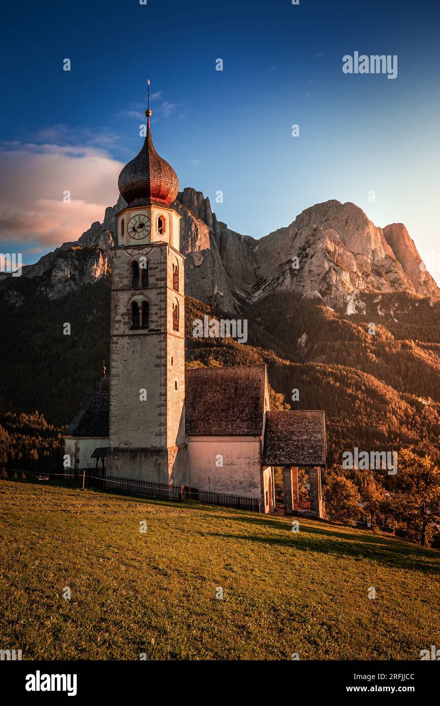 Seis am Schlern, Italia - St. Valentin e il famoso Monte Sciliar nelle Dolomiti italiane con cielo blu e luce solare calda in alto Adige su un au Foto Stock