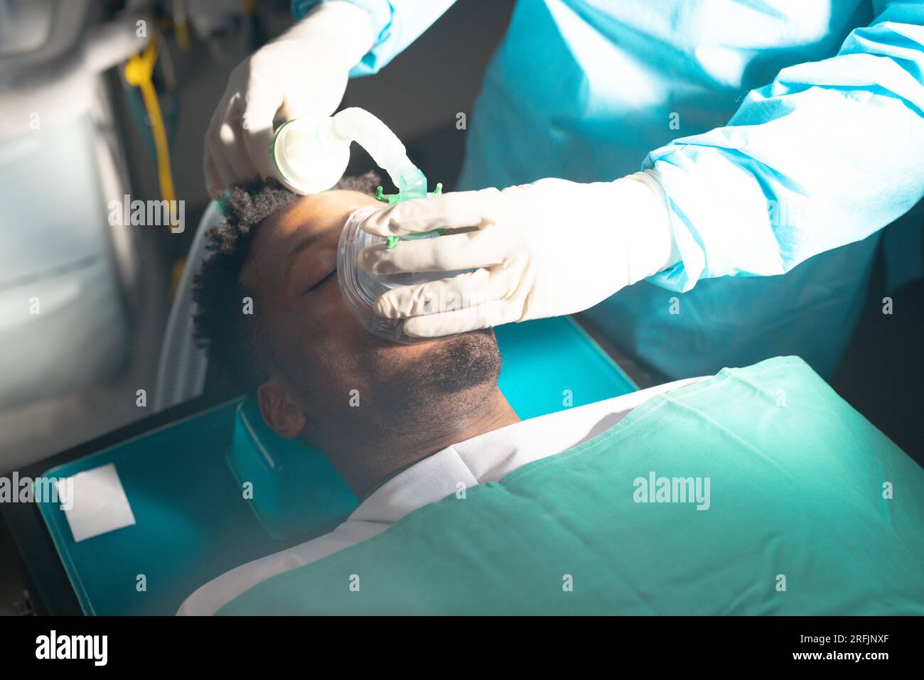 Chirurgo ponendo maschera anestetica sul paziente afro-americano in sala operatoria all'ospedale Foto Stock