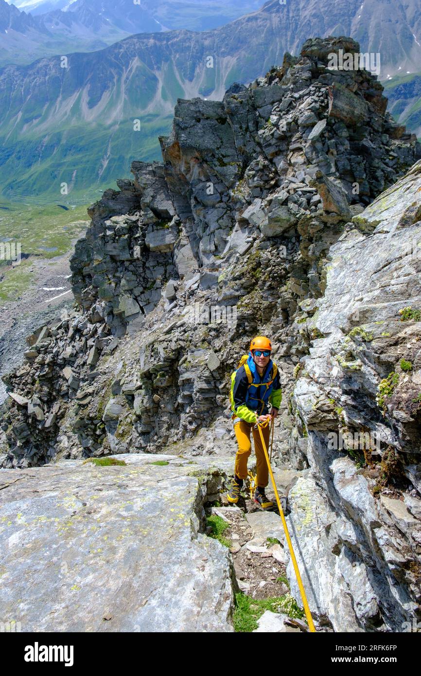 Alpinista uomo che si ripete sulle ripide rocce delle Alpi svizzere Foto Stock