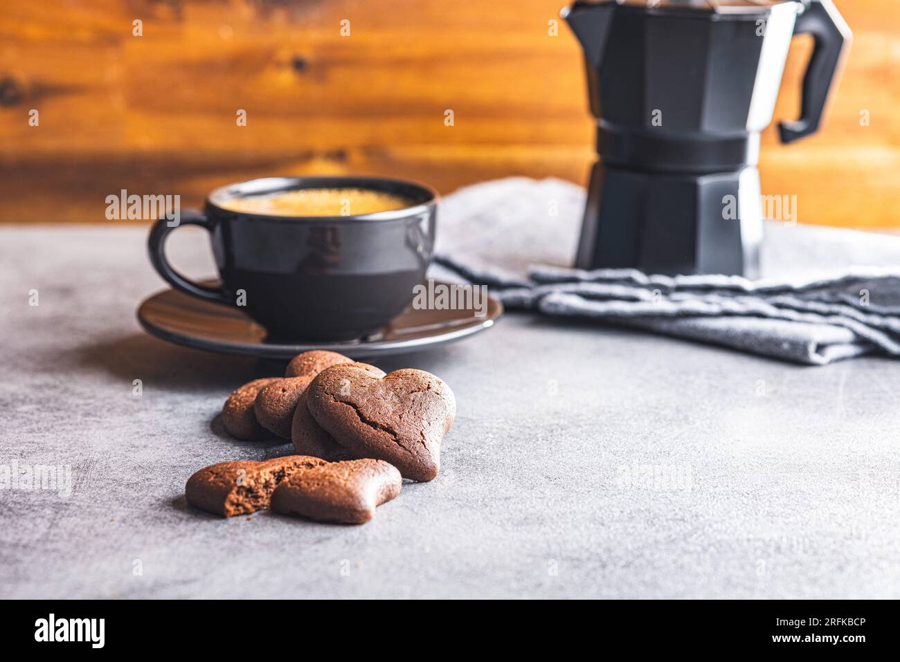 Biscotti a forma di cuore e tazza di caffè sul tavolo della cucina. Foto Stock