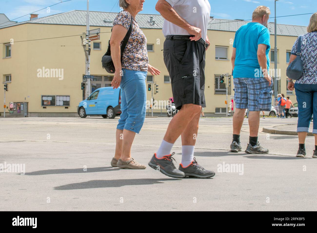 Vienna, Austria. 2 agosto 2023. Crosswalk: Tra le strade soleggiate di Vienna, quattro persone aspettano un crosswalk, desiderosi di attraversare il vivace paesaggio urbano Foto Stock