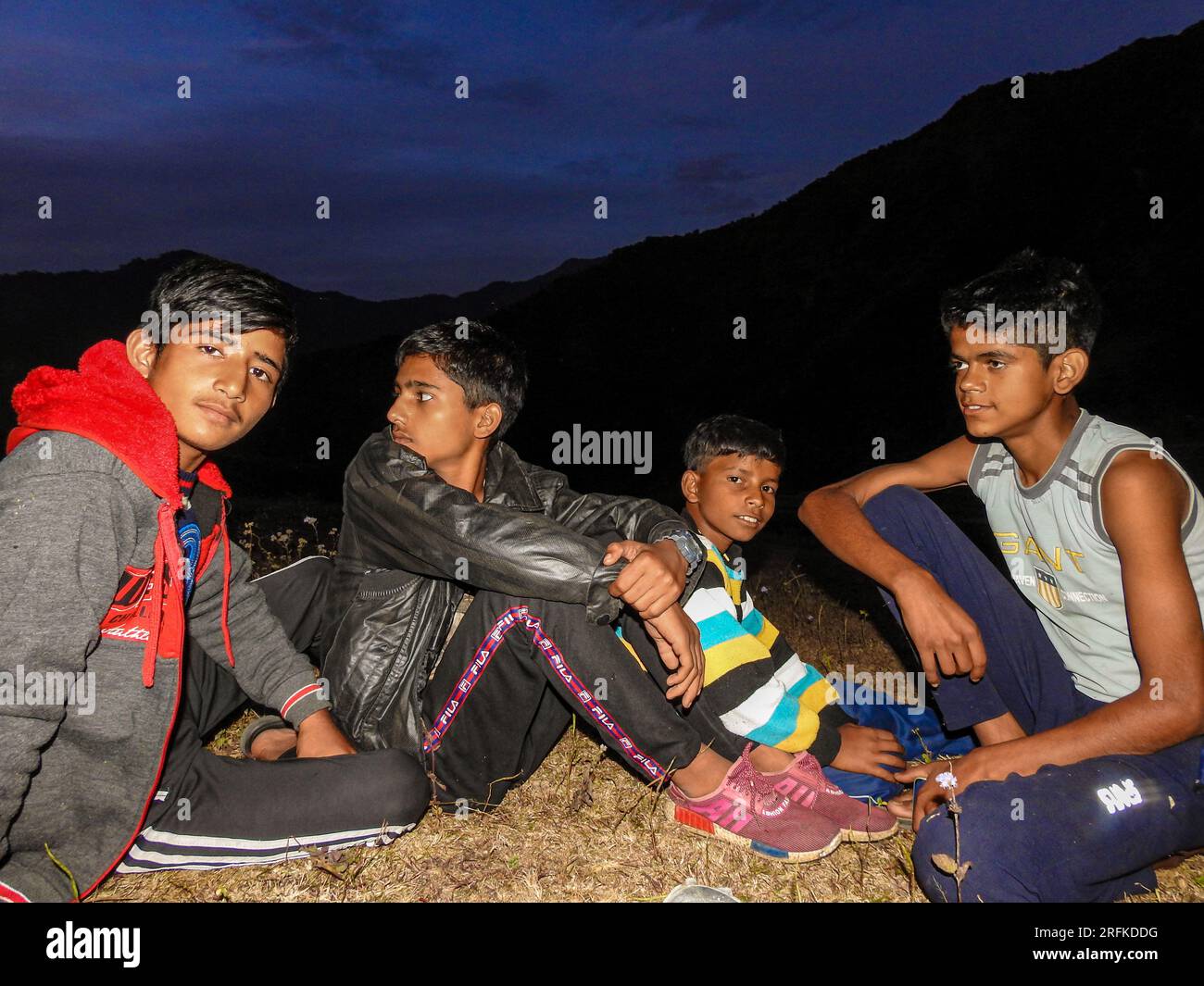 14 ottobre 2022 Uttarakhand, India. Giovani ragazzi locali si riuniscono in cima a una collina durante il tramonto, abbracciando l'incantevole crepuscolo di Uttarakhand, India Foto Stock