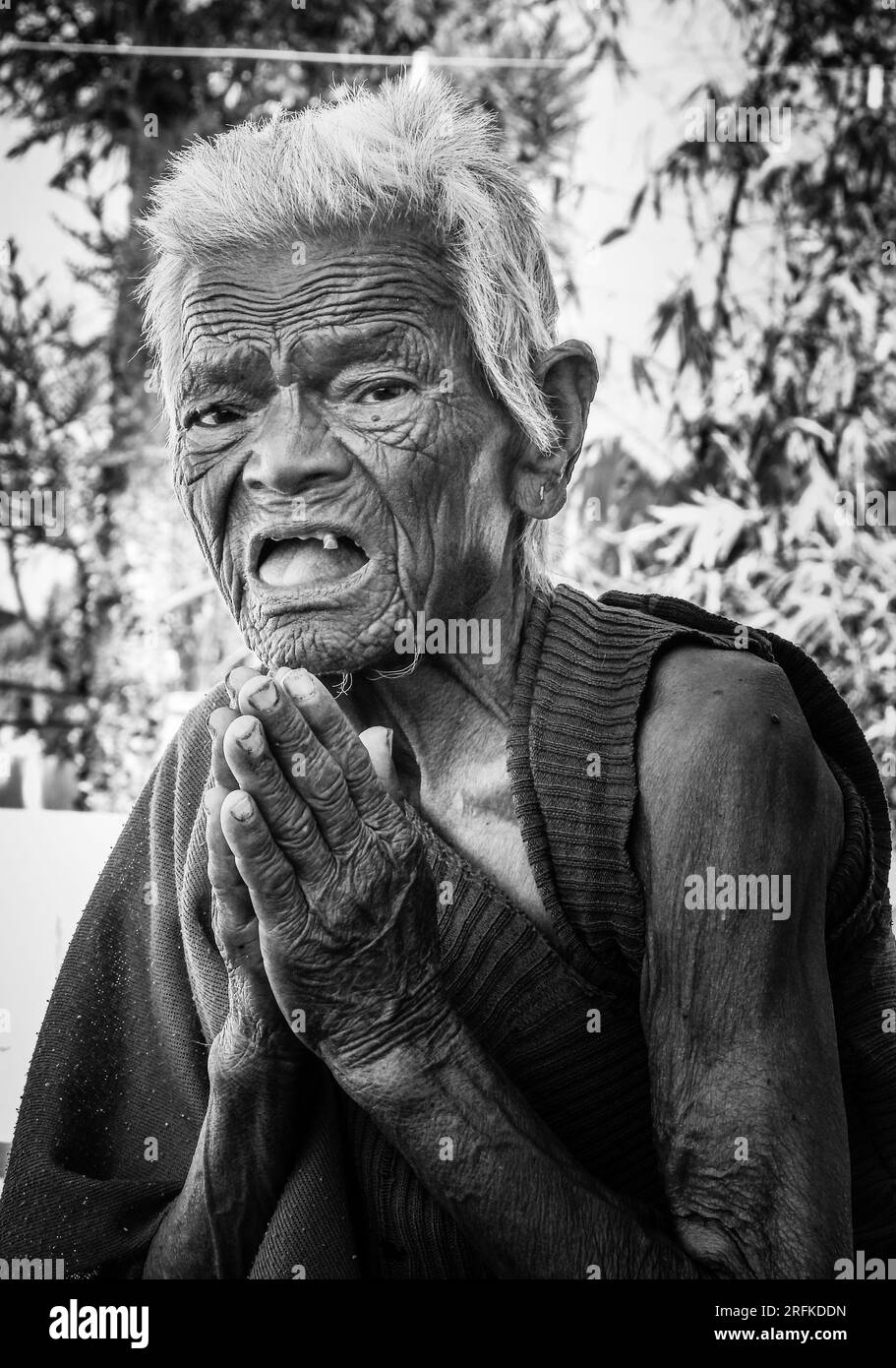 14 ottobre 2022 Uttarakhand, India. Foto monocromatica artistica di un'anziana signora indiana, in posa Namaste, che guarda la fotocamera con grazia spirituale. S Foto Stock