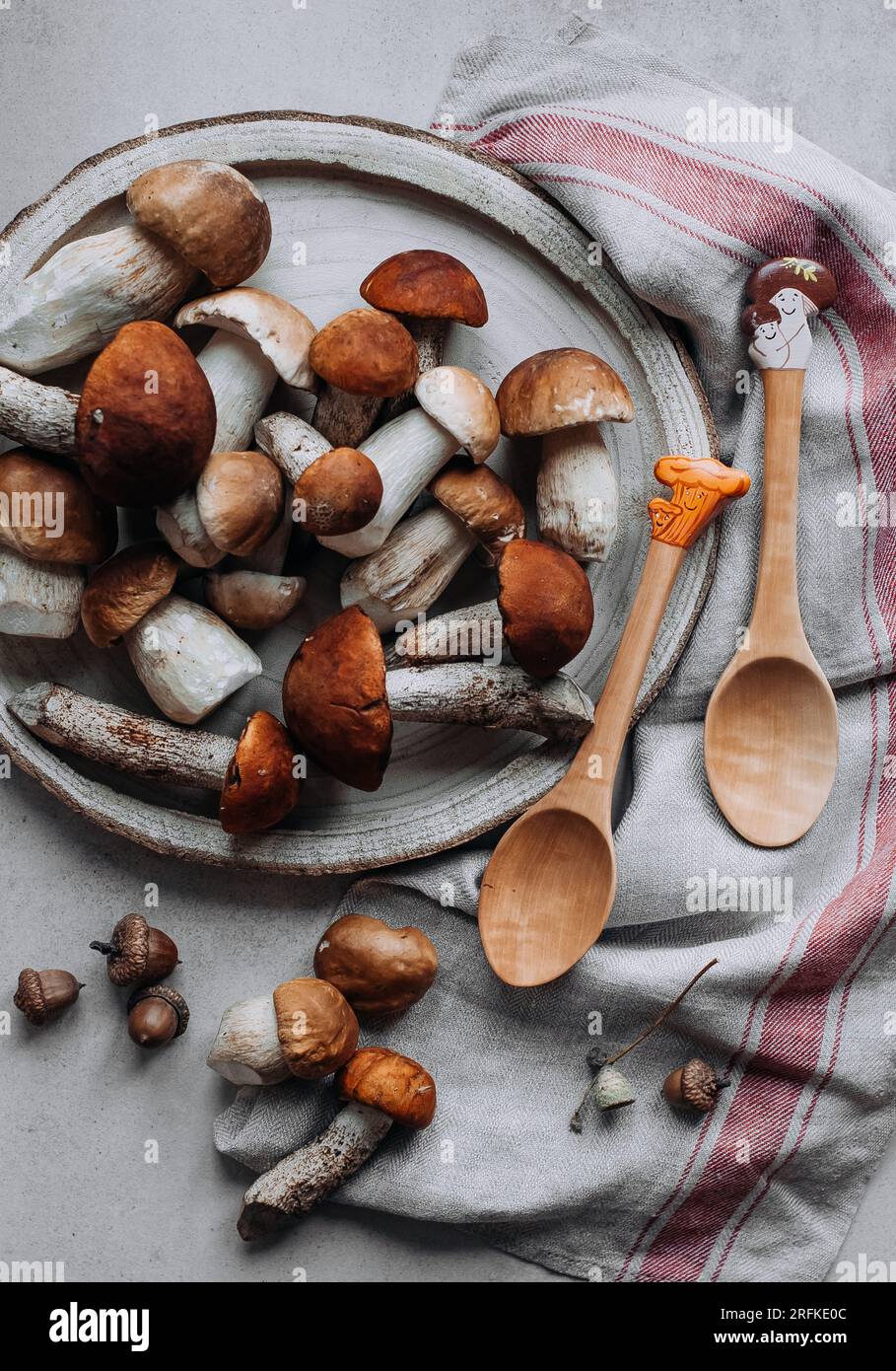 Funghi forestali, cucchiai di legno con quadri e torre di lino. Foto Stock