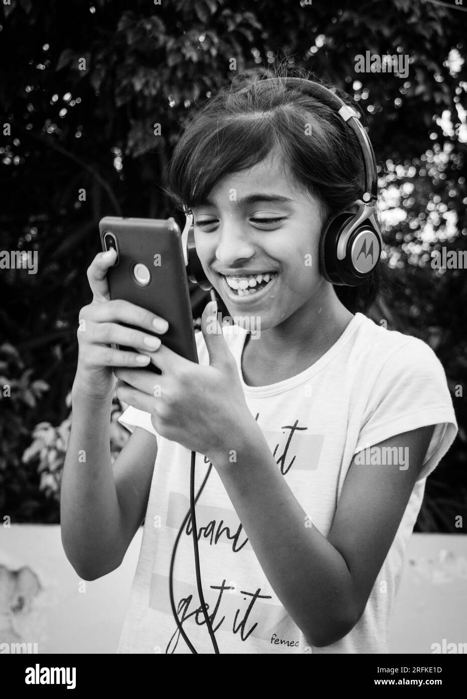 14 ottobre 2022 Uttarakhand, India. La giovane ragazza si sintonizza con piacere sulla musica sul suo smartphone indossando le cuffie. Pura gioia nel ritmo. Foto Stock