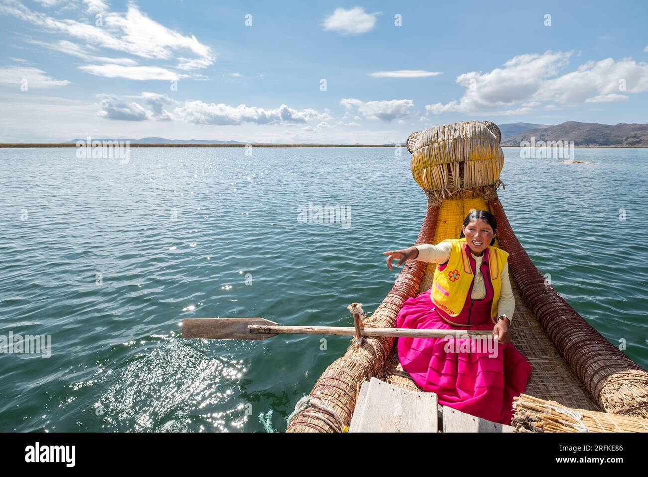 Donna, appartenente alla tribù Los Uros, naviga sul lago Titicaca Foto Stock