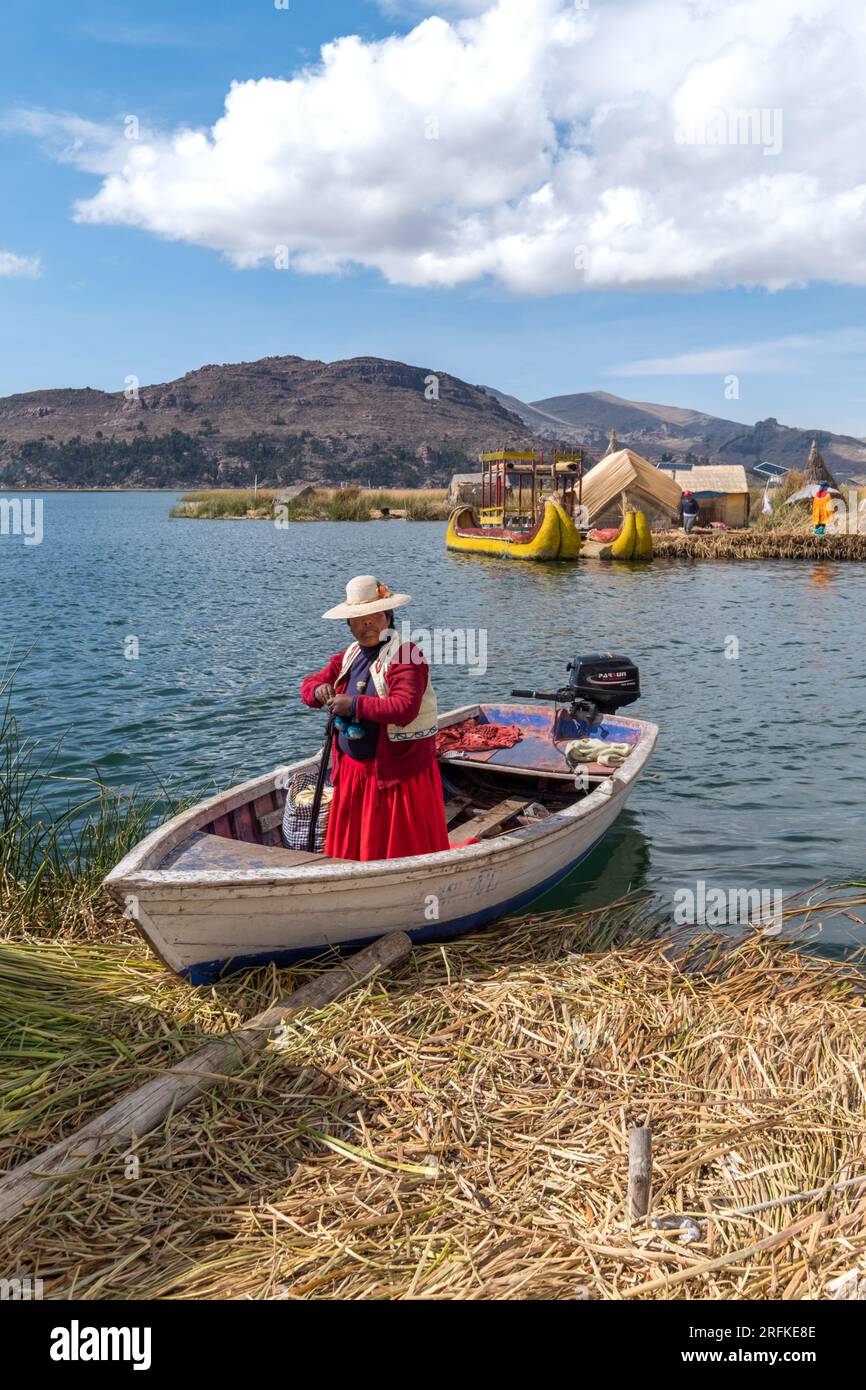 Abitante della città di Los Uros su una barca, nel lago Titicaca, in Perù Foto Stock