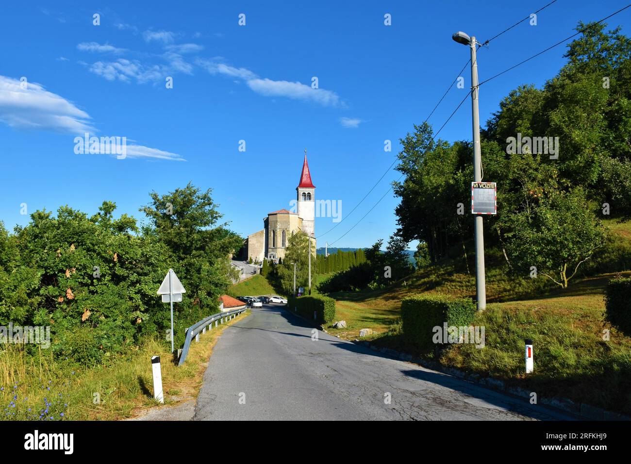 Strada che conduce verso la chiesa di st. Peter in Ilirska Bistrica nella regione di Notranjska in Slovenia e un cartello con scritto (si guida) Foto Stock