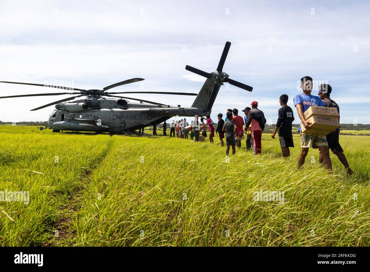 Basco, Filippine. 3 agosto 2023. Volontari filippini aiutano a scaricare i rifornimenti di emergenza da un americano Marine Corp CH-53E Super Stallion elicottero all'indomani del tifone Egay, 3 agosto 2023 a fuga Island, Filippine. L'uragano di categoria 4 attraversa parte delle Filippine con venti da 140 mph, uccidendo almeno 26 persone e causando danni estesi. Crediti: CPL. Sean Potter/US Army/Alamy Live News Foto Stock