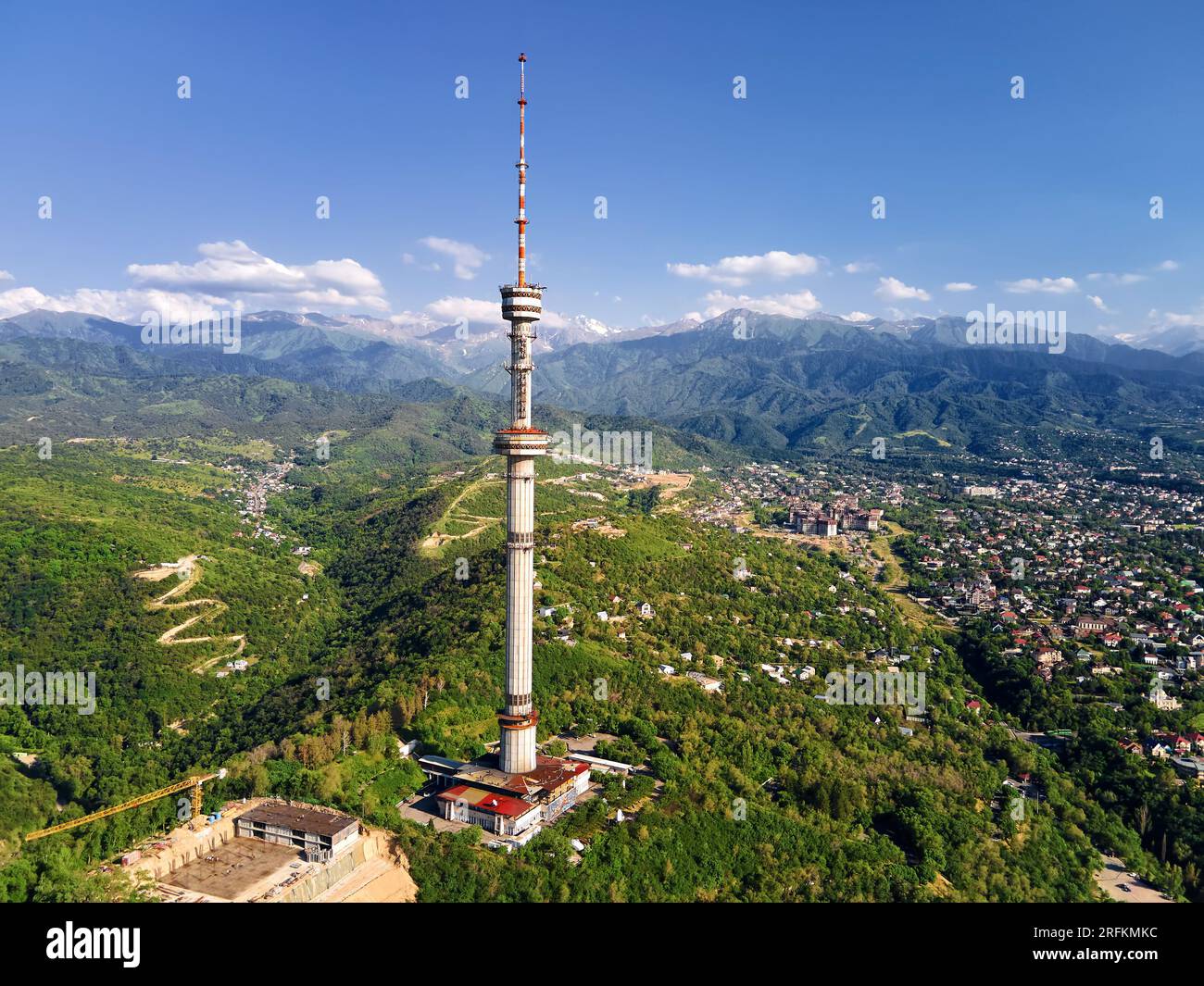 Foto aerea con drone della torre simbolo della città di Almaty e parcheggia sulla collina di Koktobe contro le montagne di neve in Kazakistan Foto Stock