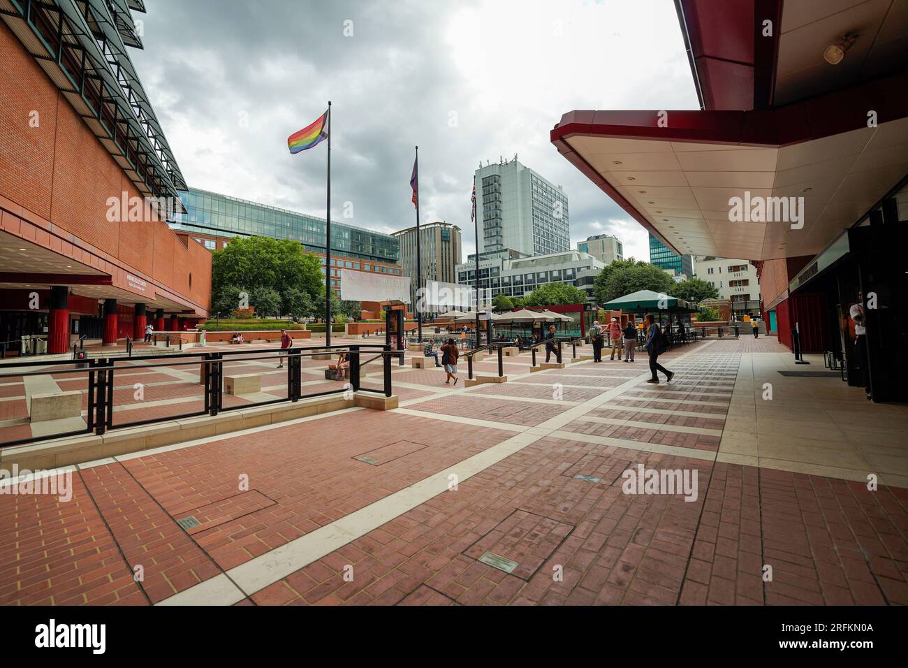 Londra, Inghilterra, Regno Unito - 31 luglio 2022. Ingresso esterno all'edificio della British Library, con persone, una bandiera dell'orgoglio del progresso che sventola dal palo della bandiera. Foto Stock