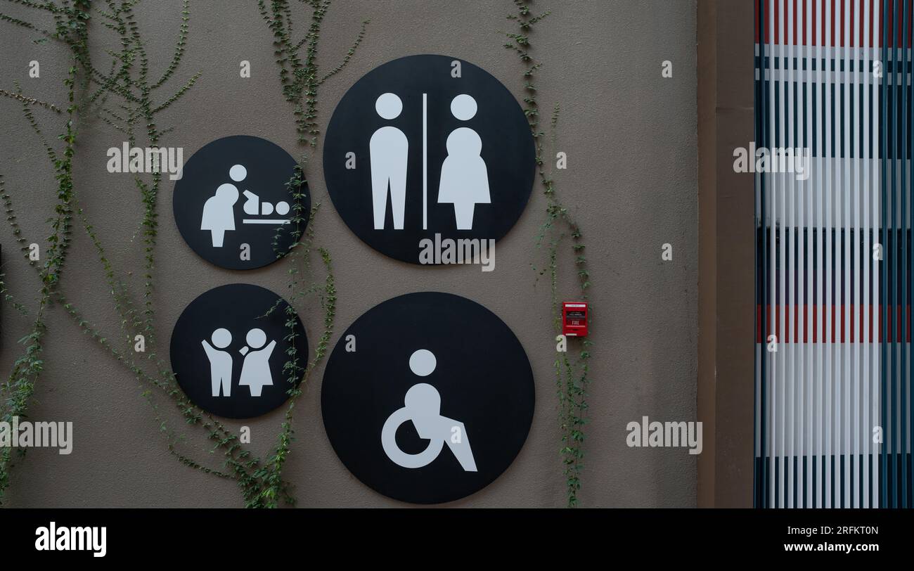 Cartello del bagno pubblico. Donna, uomini, bambini, fasciatoio per neonati e icona del gabinetto per disabili sulla parete del bagno. Icona universale dei servizi igienici pubblici. Foto Stock