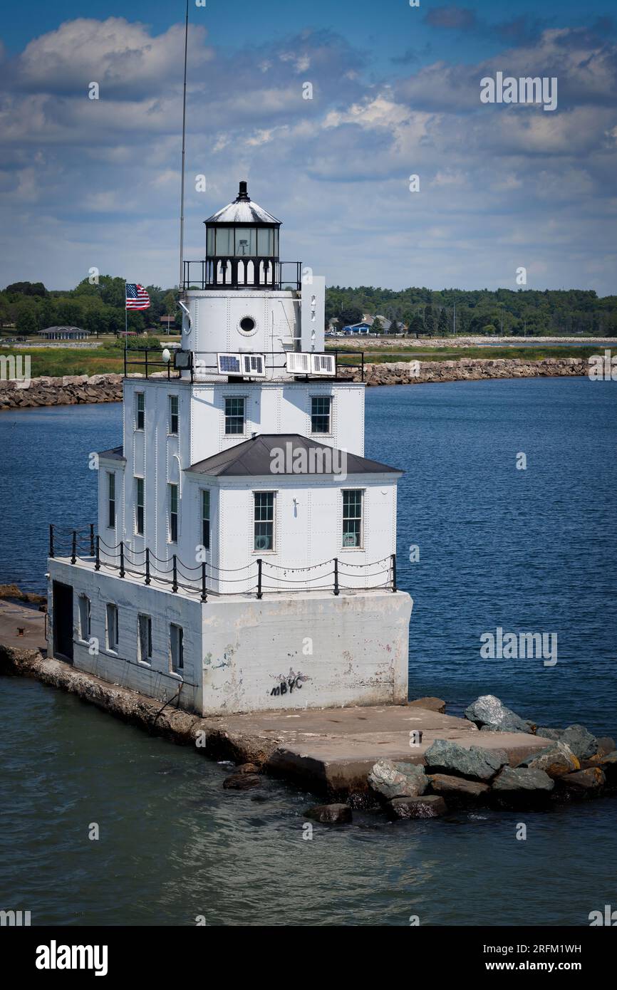 Una bandiera americana sorvola il faro del molo nord sul porto del lago Michigan a Manitowoc, Wisconsin. Foto Stock