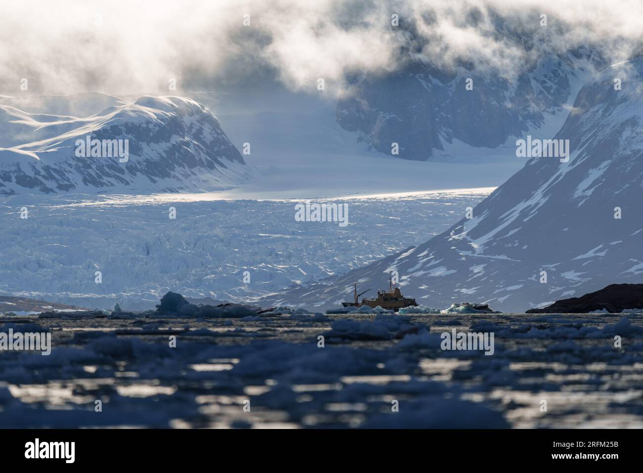 Nave da spedizione di fronte a un ghiacciaio nelle Svalbard Foto Stock