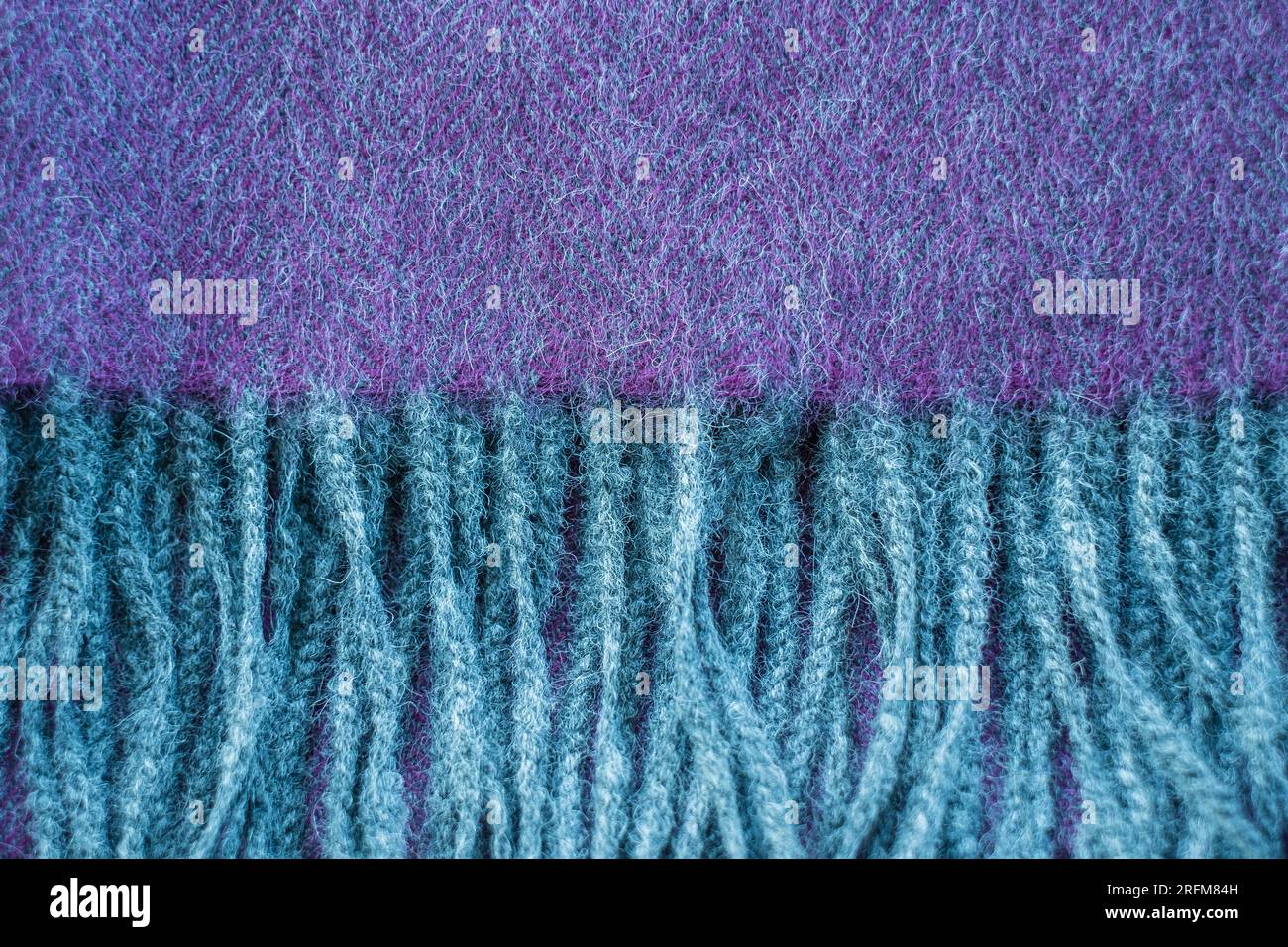 Primo piano con morbidi dettagli in lana di alpaca. Scialle a spina di pesce grigio e viola. Foto Stock