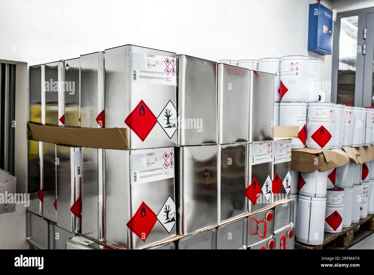 Liquido infiammabile in un contenitore metallico in un locale di stoccaggio, concetto di ricerca, manipolazione di sostanze pericolose Foto Stock