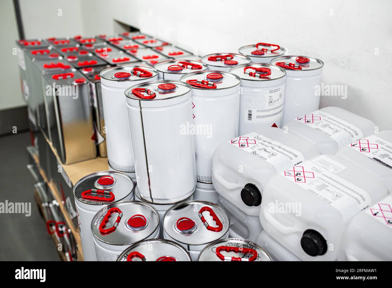 Liquido infiammabile in un contenitore metallico in un locale di stoccaggio, concetto di ricerca, manipolazione di sostanze pericolose Foto Stock