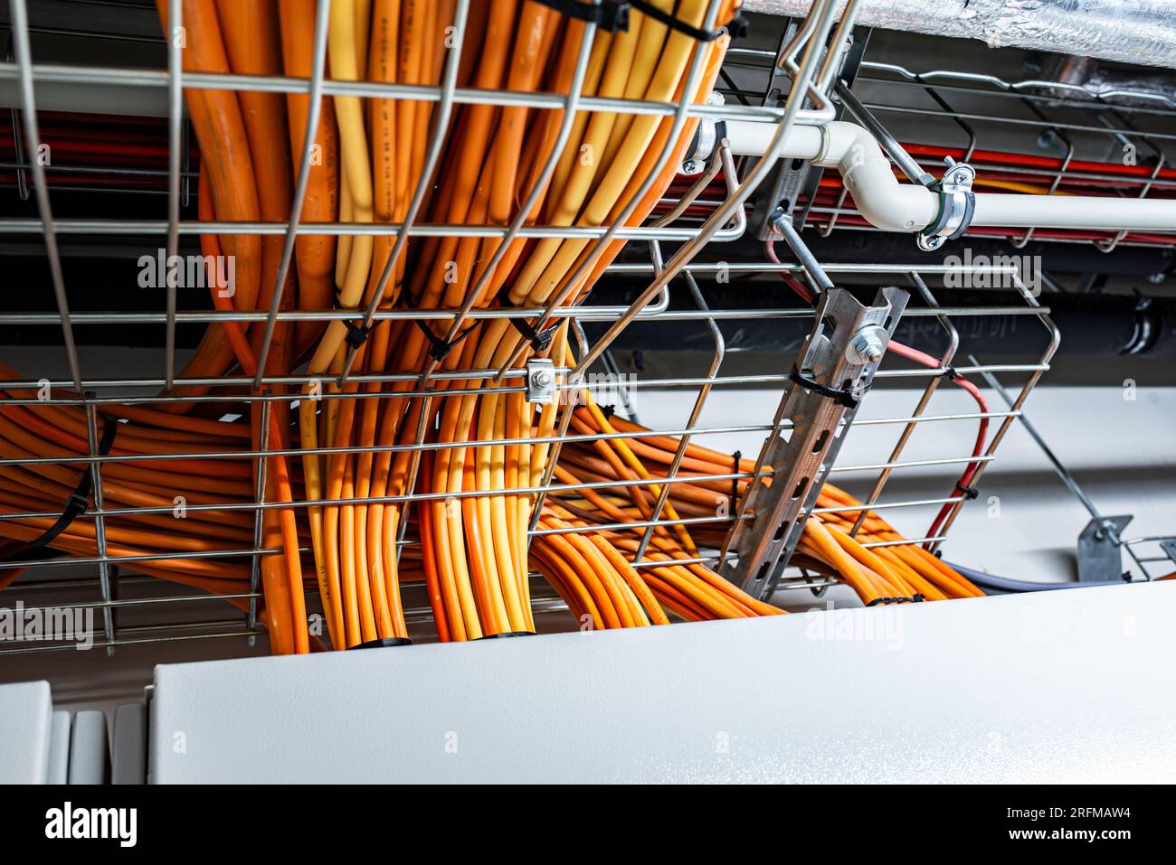 Sistema di condotti elettrici e condutture metalliche installati sul soffitto dell'edificio, cavi colorati, concetto di power House Foto Stock