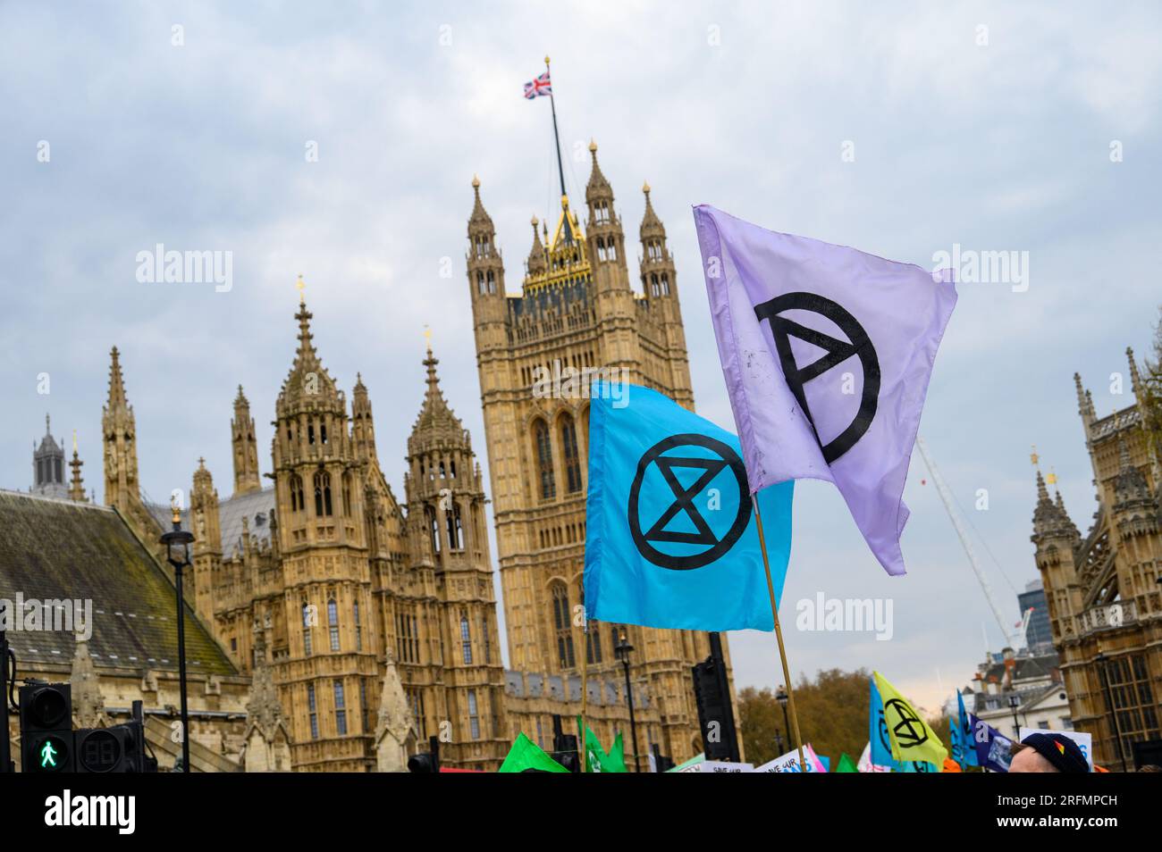 LONDRA - 22 aprile 2023: Le bandiere della ribellione dell'estinzione si tennero in alto a Londra di fronte alle Houses of Parliament, un potente simbolo dell'ambiente collettivo Foto Stock