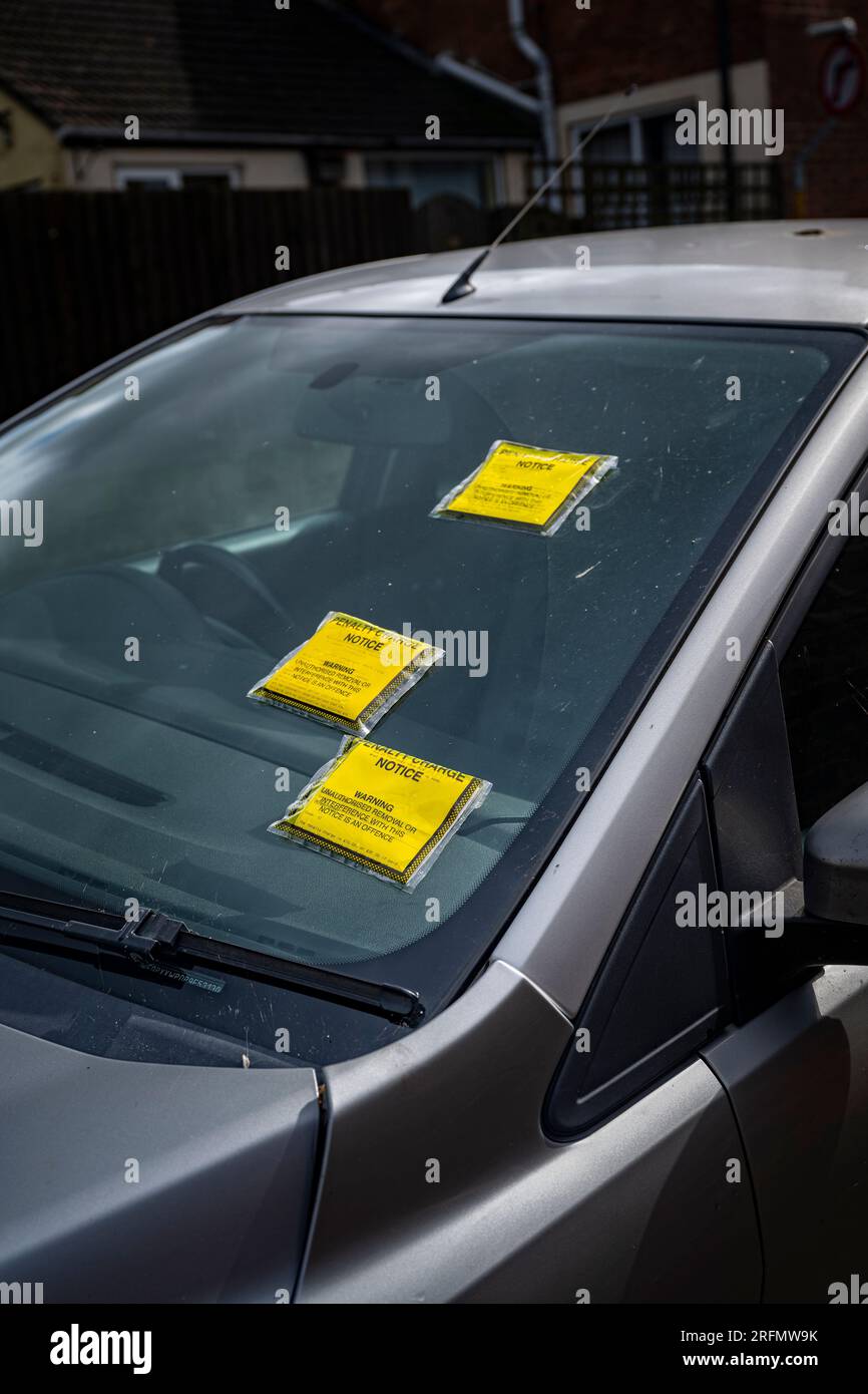 Biglietti multipli per il parcheggio o avvisi di penalità sul parabrezza di un'auto parcheggiata in strada Foto Stock