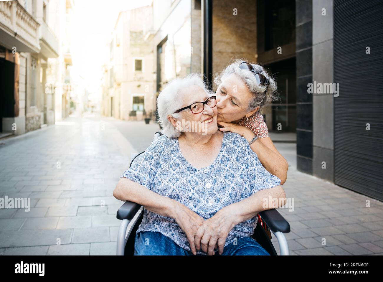 Ritratto di una donna anziana che si prende cura di sua madre su una sedia a rotelle. Donna che fa una passeggiata con sua madre che è su una sedia a rotelle. Foto Stock