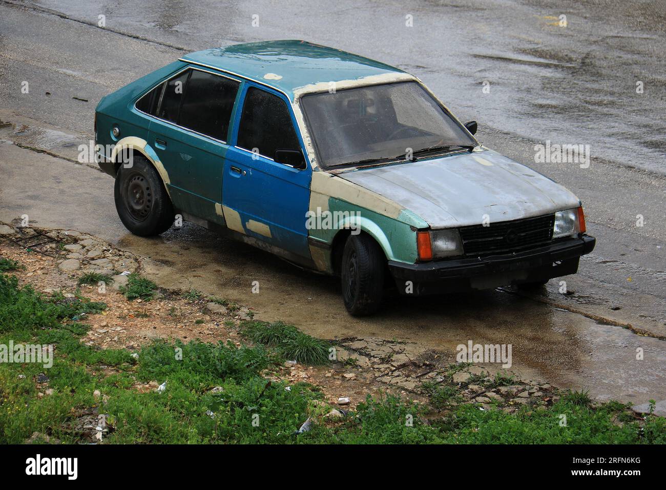 Una vecchia auto parcheggiata con vari colori di vernice. Foto Stock