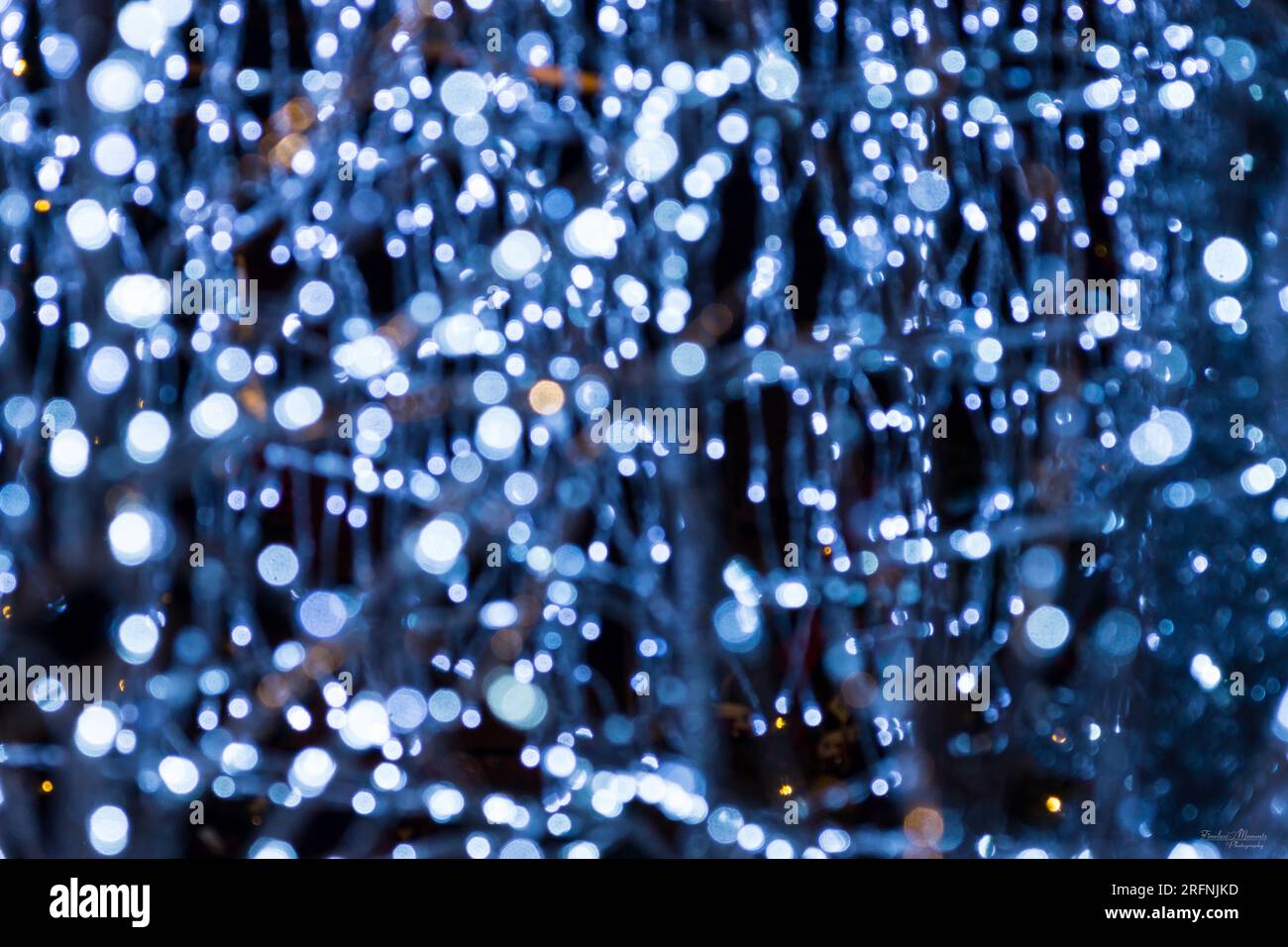 Una foto astratta di alcune decorazioni con luci di Natale blu. Questa era una cornice di alberi e pupazzi di neve. Foto Stock