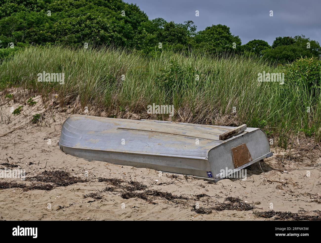 Una piccola barca a remi spiaggiata su una duna di sabbia. A West Yarmouth a Cape Cod, Massachusetts, USA. Foto Stock