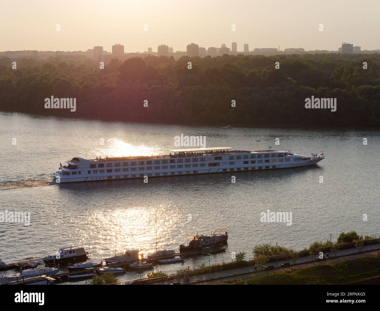Grande imbarcazione passeggeri sul Danubio in una serata estiva con molo in primo piano a Belgrado, capitale della Serbia. 4 agosto 2023, Foto Stock