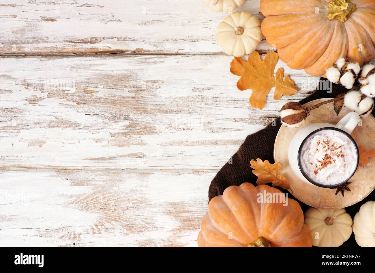 Accogliente doppio lato autunnale con zucche, foglie, maglione e latte con spezie alla zucca. Vista dall'alto verso il basso su uno sfondo rustico di legno bianco. Foto Stock