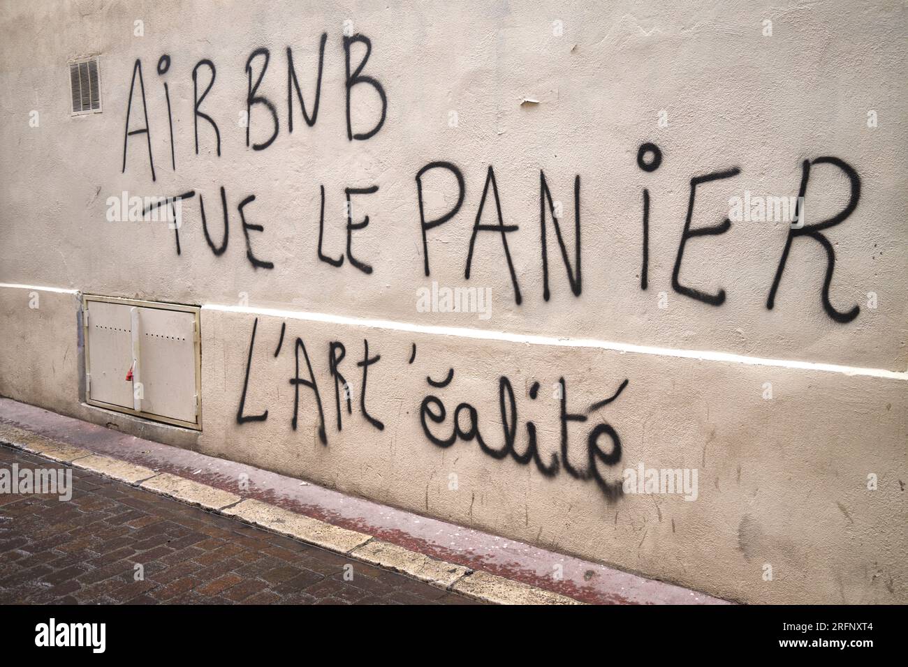 Graffiti di protesta anti Airbnb nel distretto di le Panier a Marsiglia in Francia Foto Stock