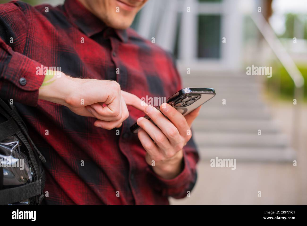 Uomo informale da vicino che usa uno smartphone moderno mentre cammina per la strada della città all'aperto, stile di vita e tecnologia, Business On the Go Foto Stock