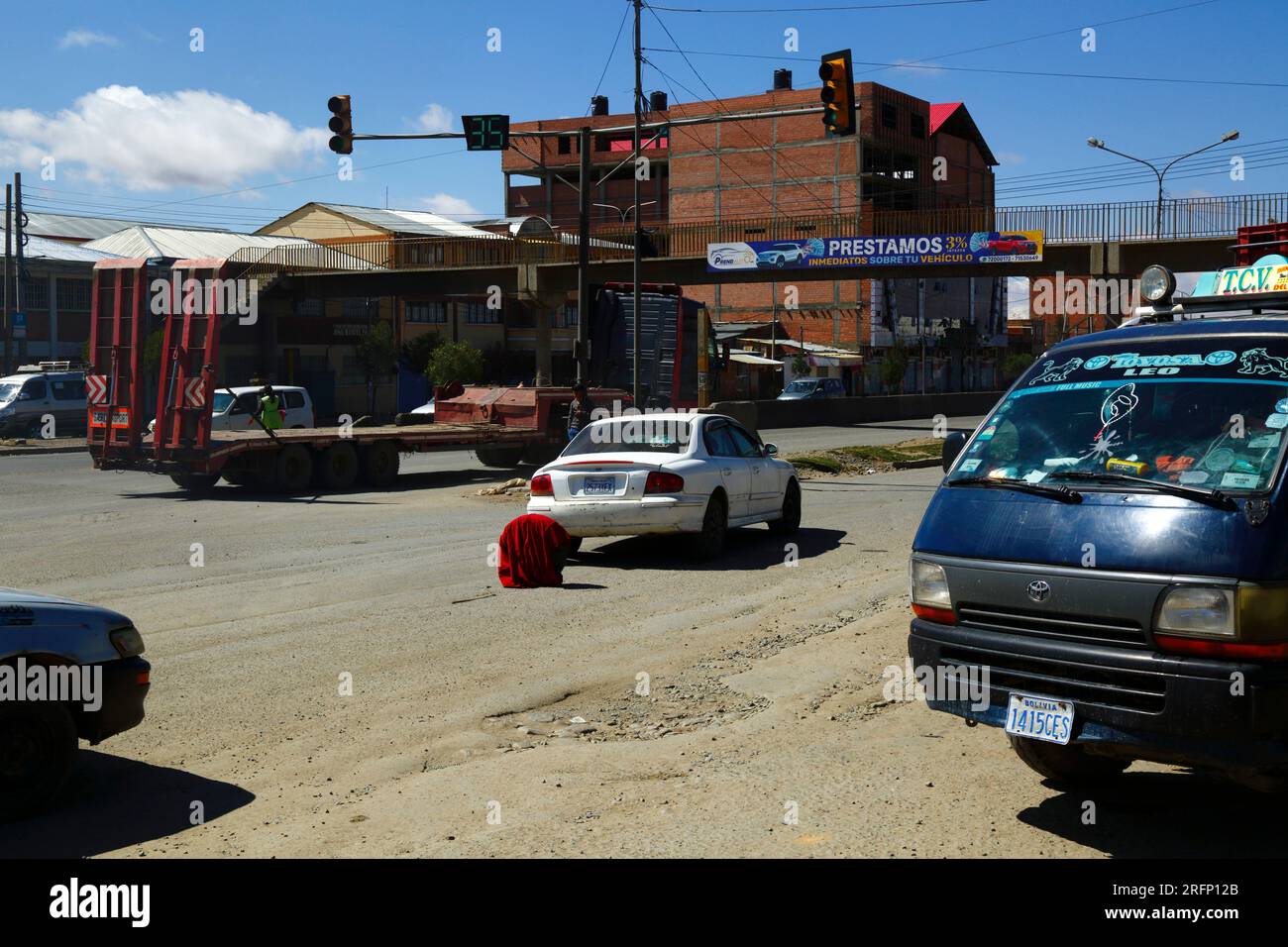 La Hyundai è rotta e la ruota coperta di coperta rossa è usata come triangolo di avvertimento nel mezzo della strada principale che attraversa Senkata, El alto, Bolivia Foto Stock