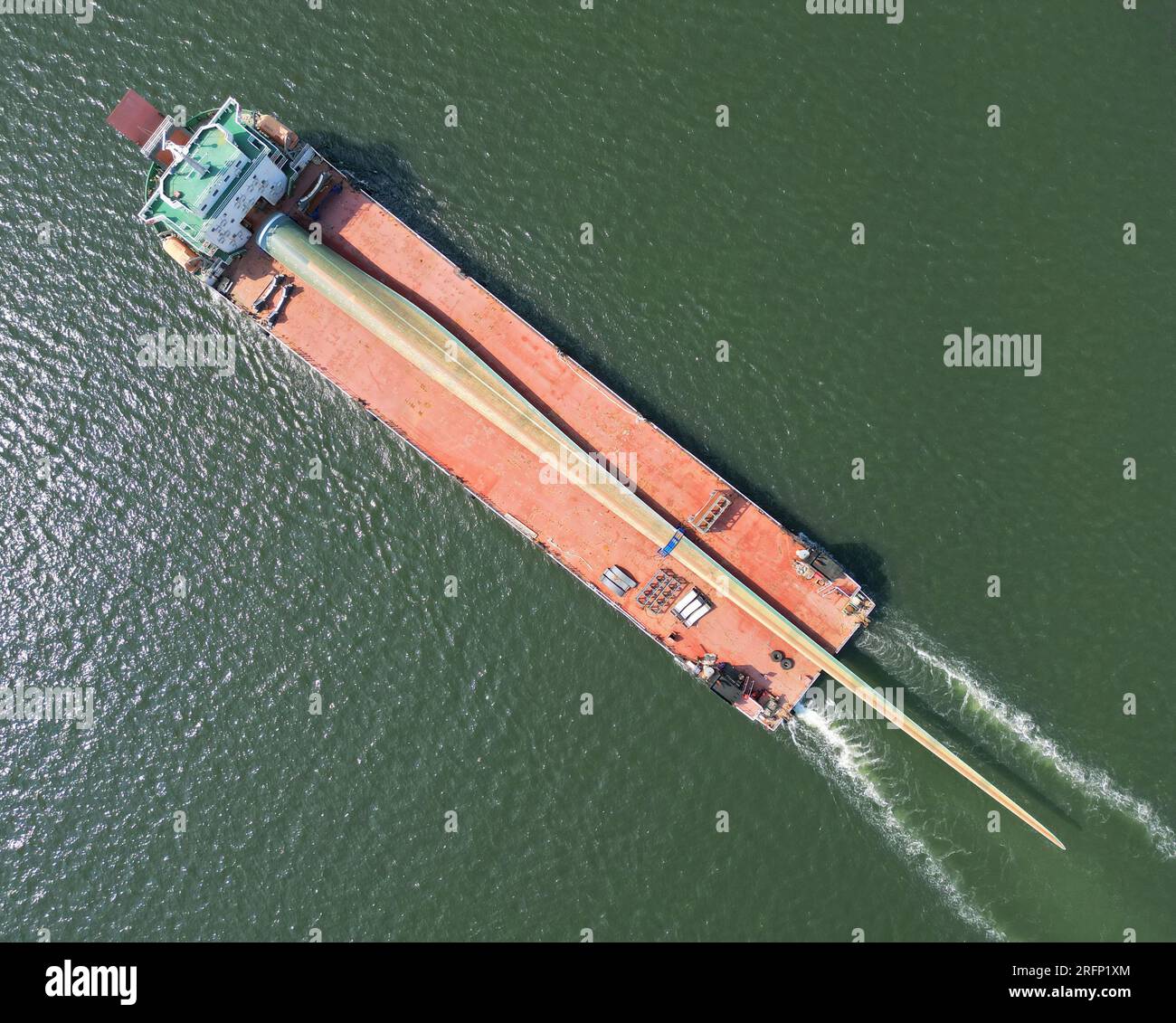 YANTAI, CINA - 4 AGOSTO 2023 - Una nave da carico che trasporta pale eoliche offshore di grandi dimensioni B1260A ormeggia nell'area del porto di Penglai nel porto di Yantai, Shan Foto Stock