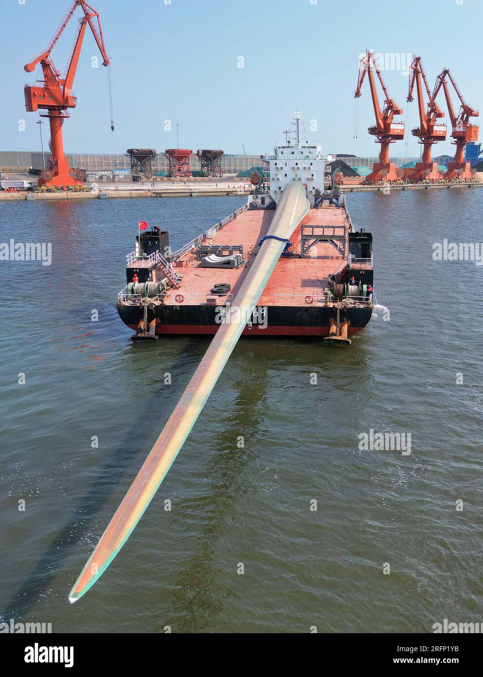 YANTAI, CINA - 4 AGOSTO 2023 - Una nave da carico che trasporta pale eoliche offshore di grandi dimensioni B1260A ormeggia nell'area del porto di Penglai nel porto di Yantai, Shan Foto Stock