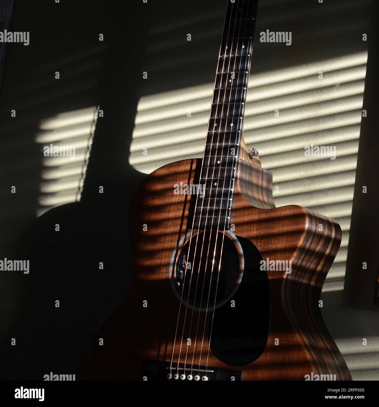 luce del sole attraverso le tende alla chitarra nella luce del pomeriggio Foto Stock