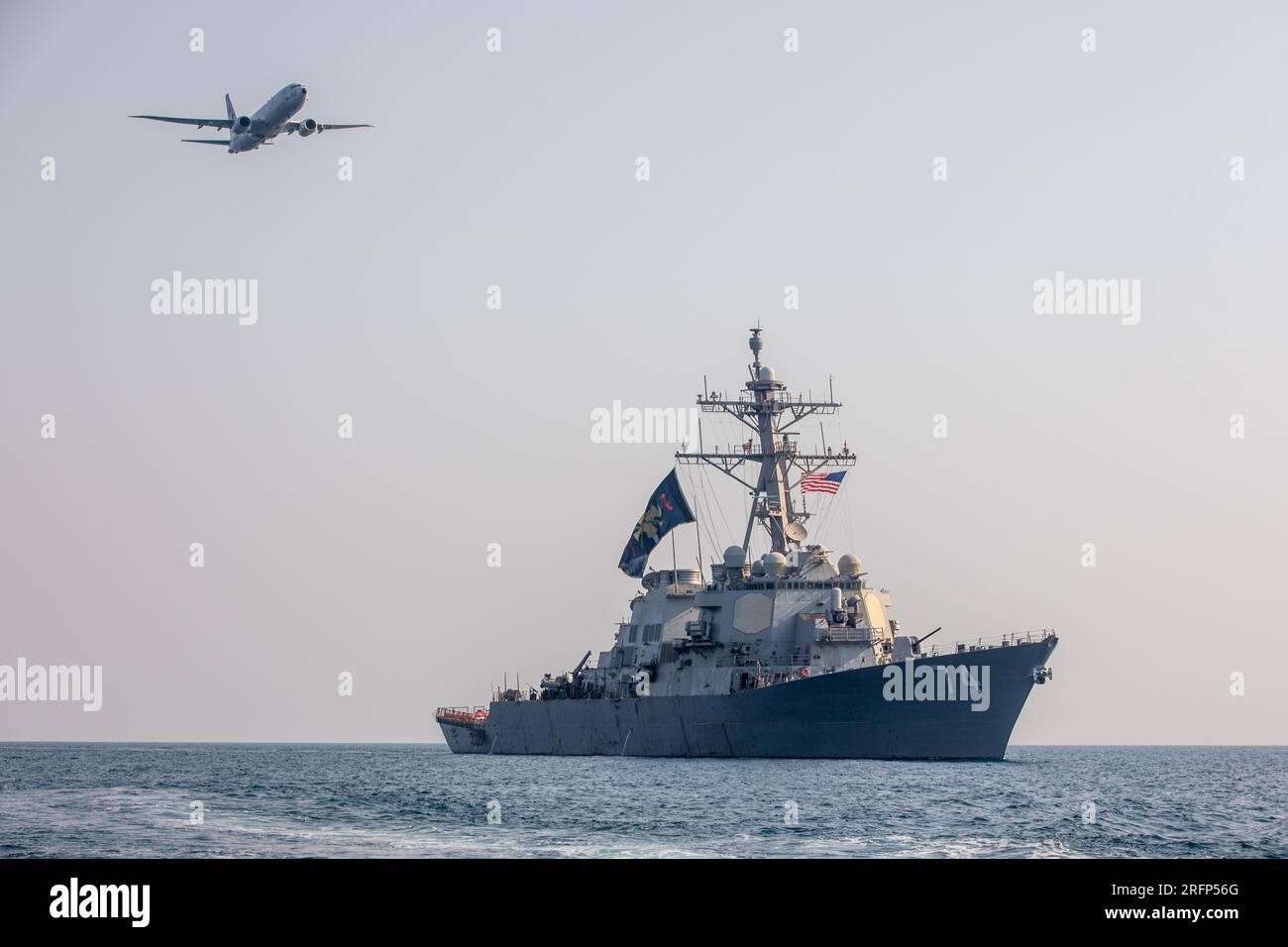 GOLFO ARABICO (3 agosto 2023) il cacciatorpediniere missilistico guidato USS McFaul (DDG 74) partecipa a un esercizio fotografico con un jet P-8 Poseidon nel Golfo Arabico, 3 agosto 2023. McFaul è schierato nell'area operativa della 5th Fleet degli Stati Uniti per contribuire a garantire la sicurezza marittima e la stabilità nella regione del Medio Oriente. (STATI UNITI Foto di Juel Foster, specialista di comunicazione di massa di seconda classe) Foto Stock