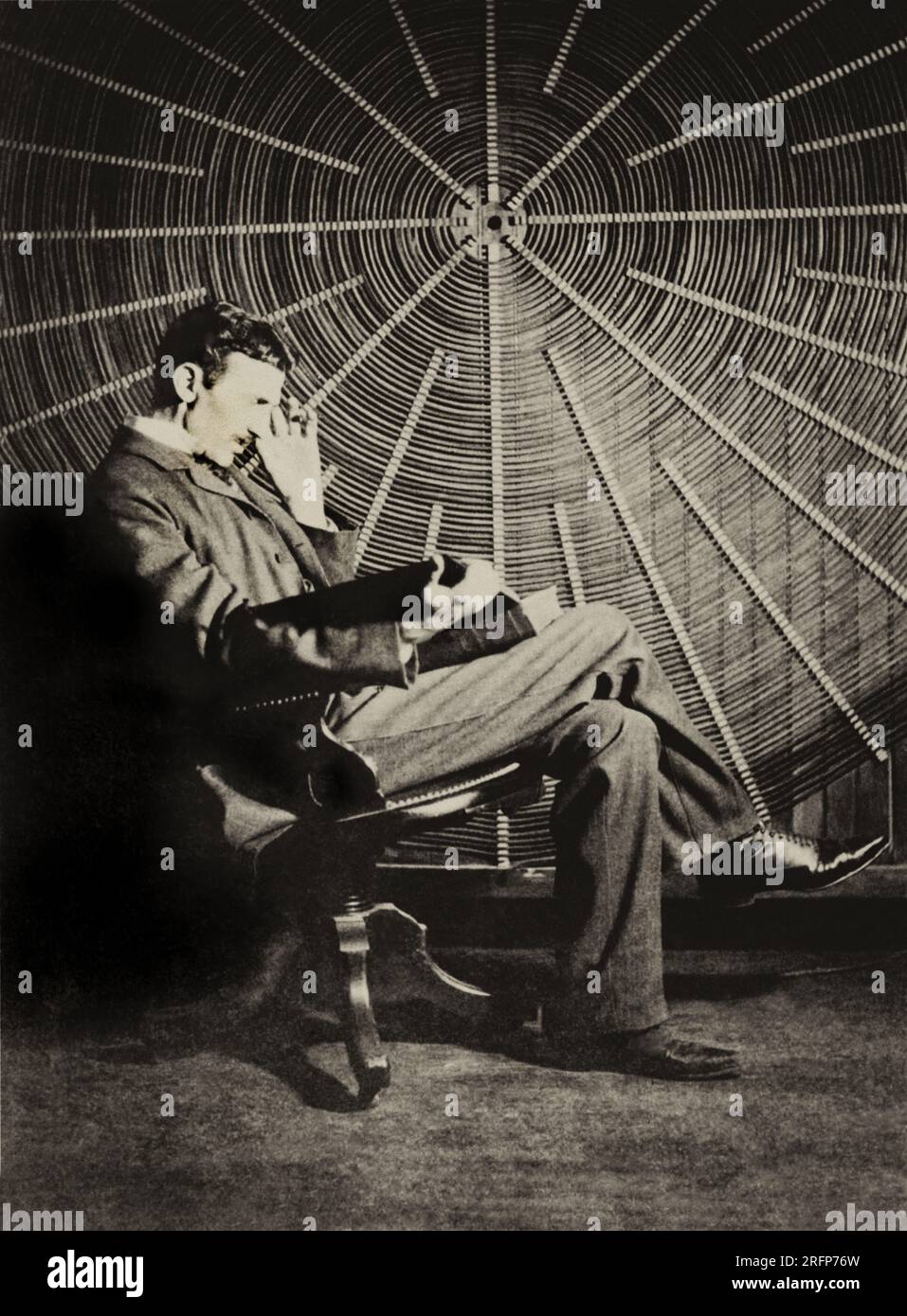 Nikola Tesla seduta accanto al generatore Foto Stock