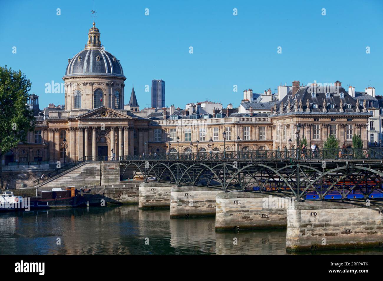 Parigi, Francia - 17 luglio 2017: Persone che attraversano la Senna sul Pont des Arts, di fronte all'Institut de France. Foto Stock