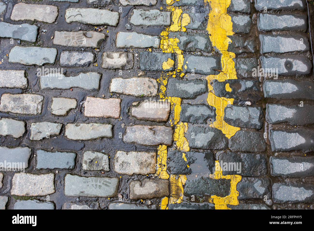 Due linee gialle su strada acciottolata, primo piano Foto Stock