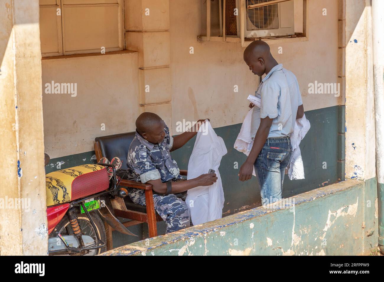 Due uomini che esaminano le lenzuola. Jinja, Uganda. Foto Stock
