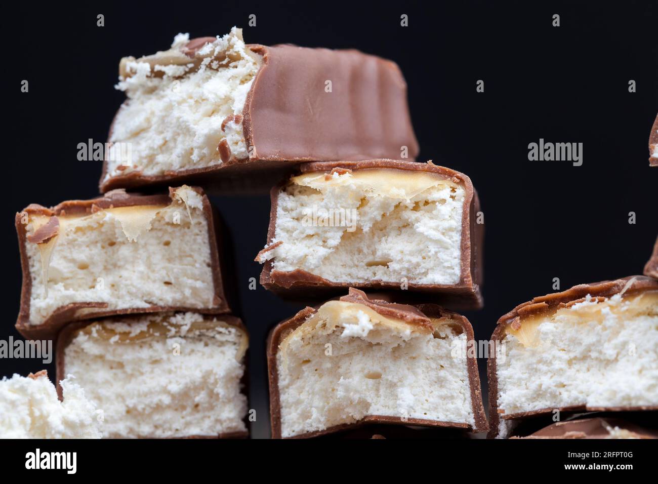 torrone cremoso ricoperto di cioccolato al latte, barretta di cioccolato a base di cacao e torrone morbido con caramello Foto Stock