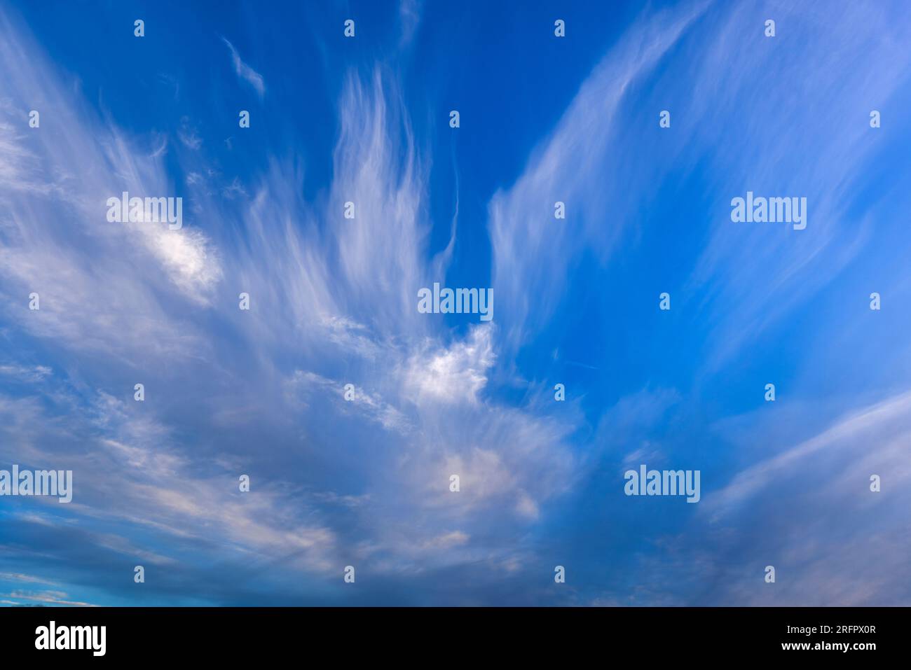 Wispy cirrus nuvole contro un cielo blu Foto Stock